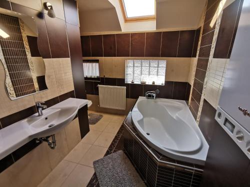 a bathroom with a large tub and a sink at Galery Apartman in Gyula