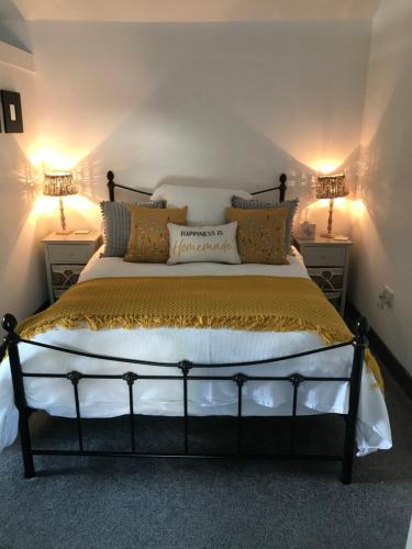 a bedroom with a large bed with two lamps at No1 The Smithy in Tattenhall