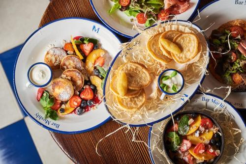 a table with three plates of food on it at Oysters & Bubbles Gastro Hotel. Rynok square in Lviv