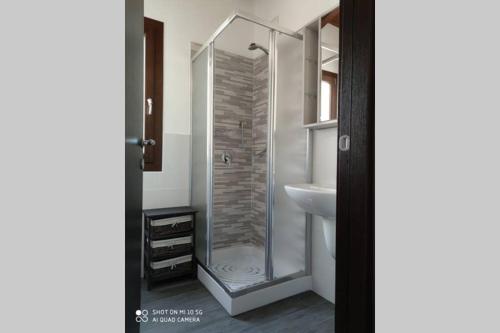 La salle de bains est pourvue d'une douche et d'un lavabo. dans l'établissement Roby's house, vivi la vacanza in relax (2L), à Marrùbiu