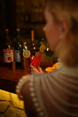 a woman sitting at a table with a drink at Lissiya Hotel in Faralya