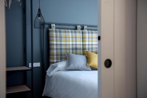 a bedroom with a bed with yellow and blue pillows at Apartaments Agulles de Montserrat in Monistrol