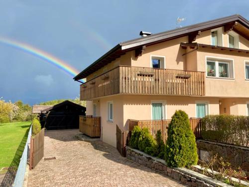 a rainbow in the sky above a house at Casa Pallanch in Fai della Paganella