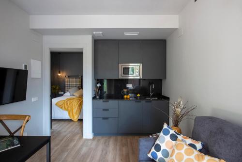 a kitchen with black cabinets and a bed in a room at Apartaments Agulles de Montserrat in Monistrol