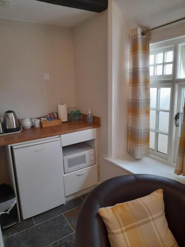 a kitchen with a counter and a microwave in a room at The Raven Inn in Ruthin