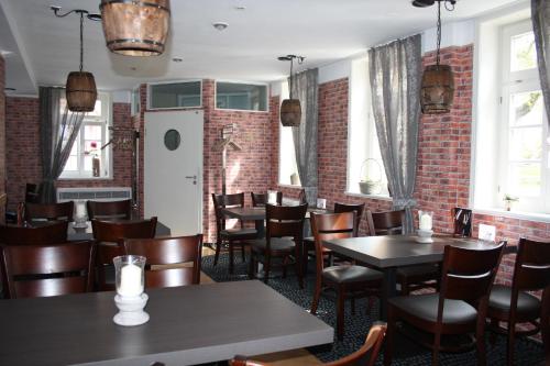 a restaurant with tables and chairs and a brick wall at Hotel & Restaurant Aragwi in Salzwedel