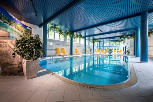 a swimming pool in a building with blue ceilings at Parkhotel in Bad Hall