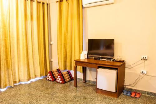 um quarto com uma televisão e uma mesa com uma mesa de sidx em The Bank River House Ayutthaya em Ban Yai (1)