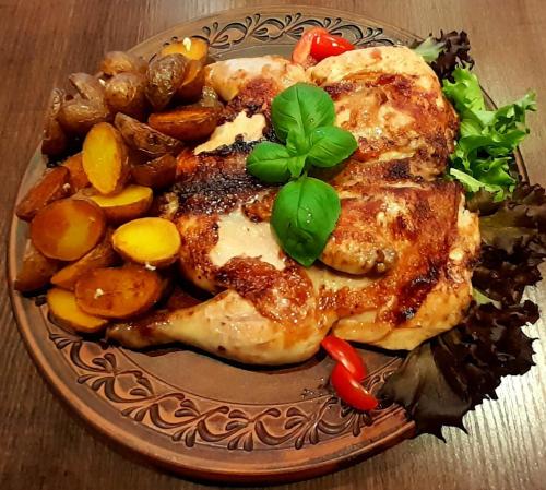 a plate of food with chicken and vegetables on a table at Hotel & Restaurant Aragwi in Salzwedel