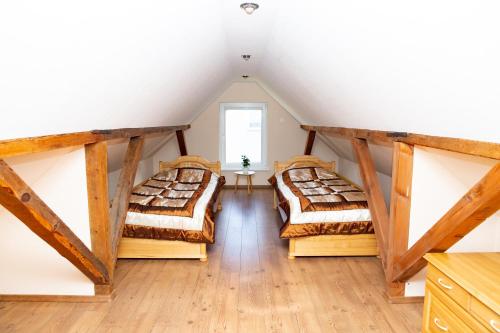 two beds in a room with a attic at Žvejo kiemelis in Šilutė