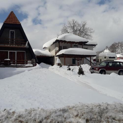 a house with a pile of snow in front of it at Vili Bilyana in Crni Vrh
