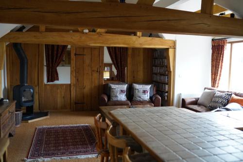 a living room with a large table and chairs at Finchden Barn in Tenterden