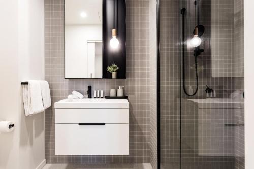 a bathroom with a white sink and a shower at Palmerston St Apartments by Urban Rest in Melbourne