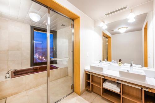 a bathroom with two sinks and a shower at Hotel Nord Otaru in Otaru