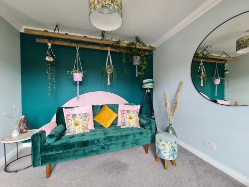 ein grünes Sofa in einem Zimmer mit blauer Wand in der Unterkunft EDEN Apartment, Oban in Oban