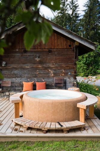 a hot tub on a deck next to a cabin at Chalet sur les monts Morzine in Montriond