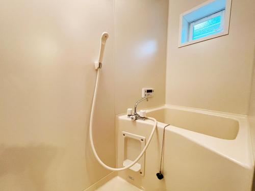 a bathroom with a bath tub with a shower at るり渓 フレアキャビン in Nantan city
