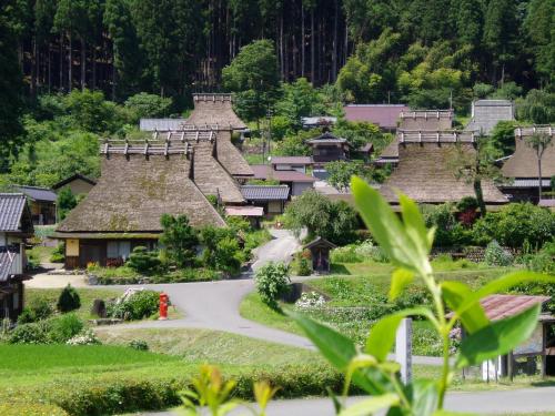 a village with thatched roofs and a road at るり渓 フレアキャビン in Nantan city