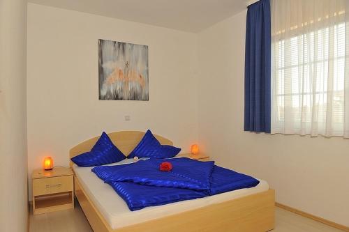 sypialnia z łóżkiem z niebieskimi poduszkami w obiekcie Apartment in Rovinj with balcony, air conditioning, Wi-Fi (230-1) w Rovinj