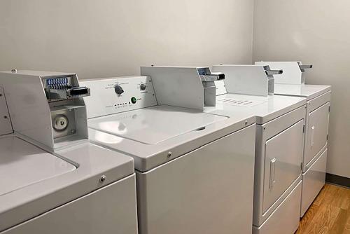 a row of white washing machines in a room at Travelodge Inn & Suites by Wyndham Missoula University Park in Missoula