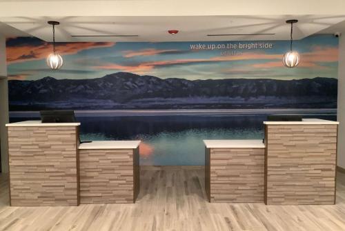 a wall with a painting of a lake and mountains at La Quinta Inn & Suites by Wyndham Littleton-Red Rocks in Littleton