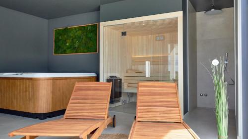 two wooden chairs and a table in a room at Villa Green Forest with wellness and heated salty pool in Hum