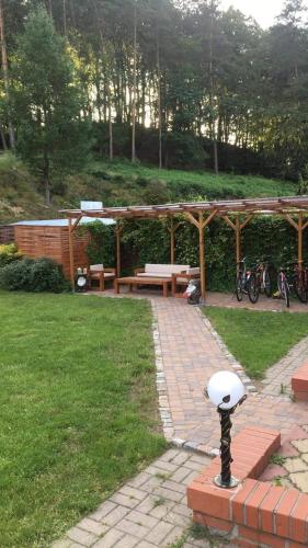 a picnic area with a bench and a picnic table at 4 Pory Roku Apartamenty Domki Pokoje in Nadole