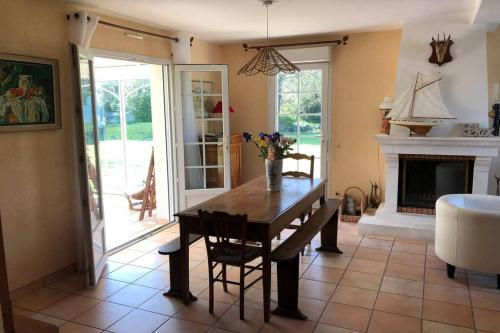 une salle à manger avec une table et une cheminée dans l'établissement Belle maison néo-bretonne à 5 minutes de la mer, à Tréveneuc