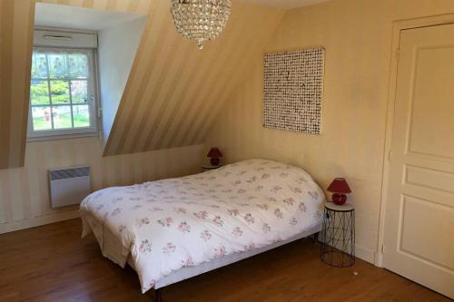 une chambre avec un lit et un lustre dans l'établissement Belle maison néo-bretonne à 5 minutes de la mer, à Tréveneuc