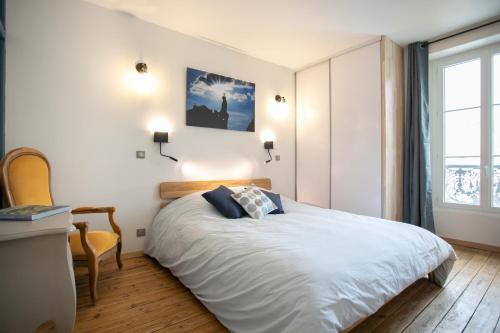 um quarto com uma cama, uma secretária e uma janela em Péribleu em Périgueux