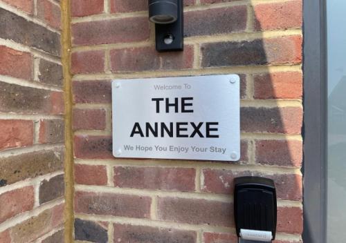 a sign that says the answer on a brick wall at The Annexe - Pagham in Pagham