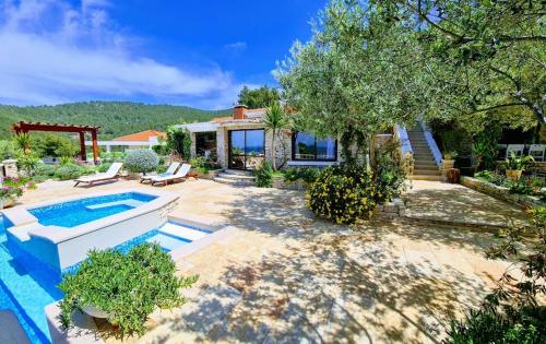 a backyard with a swimming pool and a house at Villa Stone House Poplat in Vela Luka
