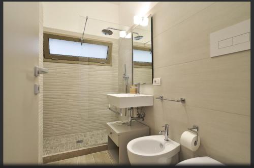 a bathroom with a white toilet and a sink at Mediterraneo Apartments ORO in Marzamemi