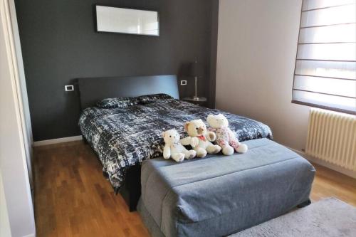 tres ositos de peluche sentados encima de una cama en Apartamento moderno muy acogedor y luminoso •León en León