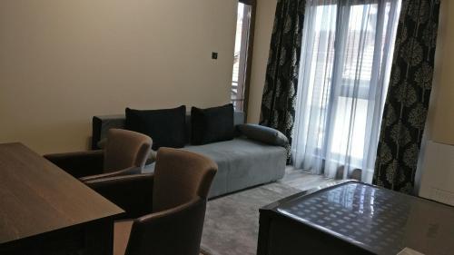 a living room with a couch and a table at Къща за гости Роял in Sandanski
