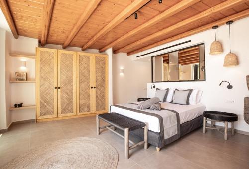 a bedroom with a bed and a wooden ceiling at Ikies of Mykonos in Mýkonos City