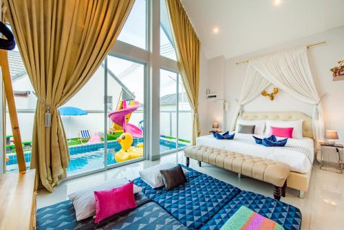 a bedroom with a large bed and a pool at M4 Billion Pool Villa Cha-am in Cha Am