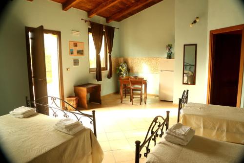 a room with two beds and a kitchen with a table at Al Grande Gelso in Cariati