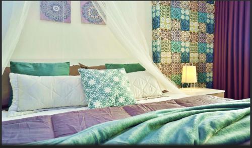 a bedroom with a bed with pillows and a canopy at Mediterraneo Apartments ARGENTO in Marzamemi