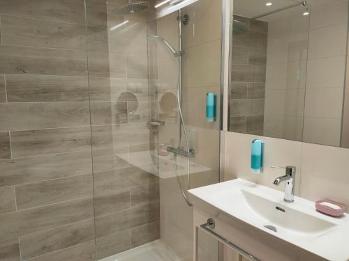 a bathroom with a sink and a shower at Apartament 309 Natalie Seaside Park in Kołobrzeg