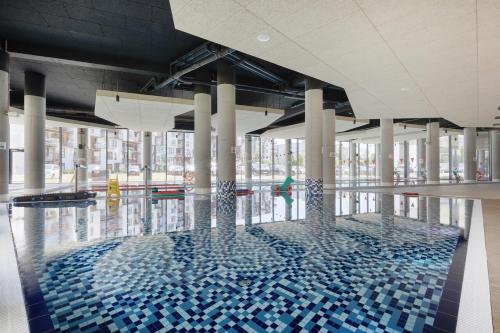 コウォブジェクにあるApartament 309 Natalie Seaside Parkの建物内の青いタイルが敷かれた大きなプール
