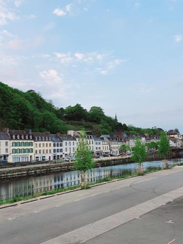 a street next to a river with white buildings at Chambres Dhôtes Numéro 1 in Châteaulin