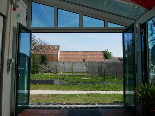 an open glass door looking out into a yard at Bonito - Historischer Streckhof in Schützen am Gebirge