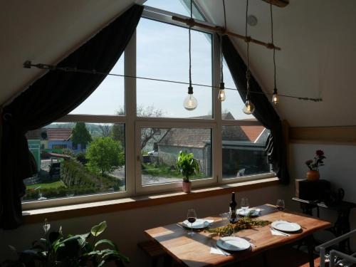 a table in a room with a large window at Bonito - Historischer Streckhof in Schützen am Gebirge