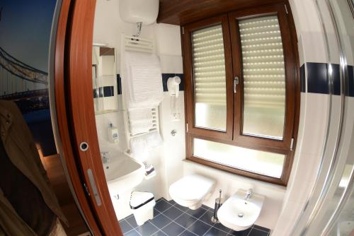 baño con aseo y lavabo y ventana en B&B Europa, en Potenza
