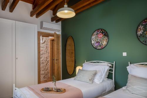 two beds in a room with green walls and mirrors at Villa Kameni dvori in Sveti Filip i Jakov