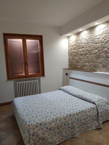 um quarto com uma cama e uma parede de pedra em Soggiorno in Relax em Correggioverde