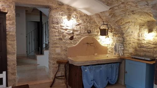 a kitchen with a sink in a stone wall at B&B Taverna Paradiso in SantʼAmbrogio di Valpolicella