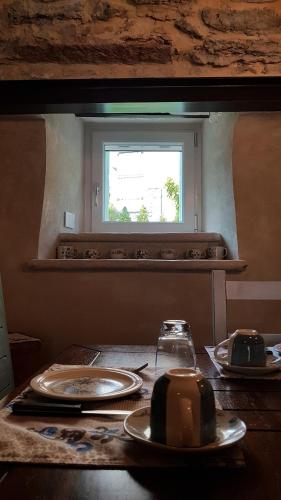 a table with plates on it with a window at B&B Taverna Paradiso in SantʼAmbrogio di Valpolicella