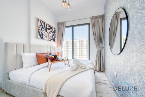 a bedroom with a large bed and a mirror at Chic 1BR in Town Square UNA Dubailand by Deluxe Holiday Homes in Dubai